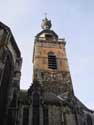 Collégiale Saint-Ursmer  / Sint-Ursmarus kapittelkerk BINCHE foto: De toren uit bestaat uit drie delen. De basis werd uitgevoerd in plaatselijke zandsteen en bevat een gotisch raam van de tweede helft van de 15de eeuw. De verdieping erboven werd opgebouwd rond 1583 in baksteen en bevat vier galmgaten. Het bovenste gedeel