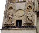Stadhuis en belfort AALST foto: De twee halfverheven beelden op de voorgevel van de Belforttoren stellen de Graven van Vlaanderen en de Graven van Aalst voor.   De zonnewijzer tussen de twee beelden was aanvankelijk zo oud als de belforttoren zelf. In 1600 werd echter een nieuwe zonnewi