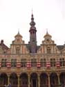 Borse van Amsterdam AALST foto: Bijzonder zijn de paren van klokvormige geveltoppen, met de torenspits in het midden. Let ook op de eenvoudige kruiskozijnen op de tussenverdieping, waarvan de horizontale as doorloopt in het lijstwerk op de muur